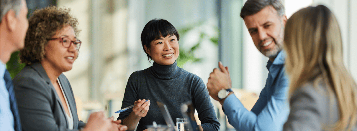 Group of employees talking at a boardroom table