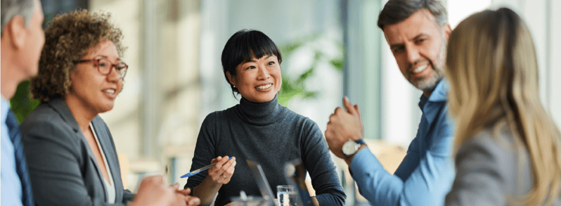 Group of employees talking at a boardroom table