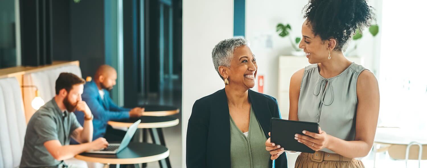 To women in an office looking at a tablet.