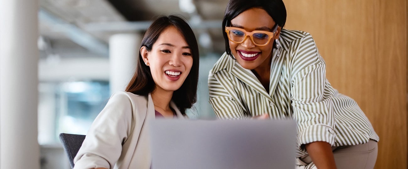 Two women in an office looking at a laptop