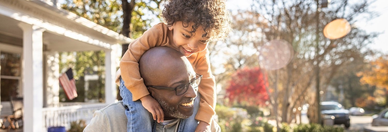 Man with child on his shoulders smiling