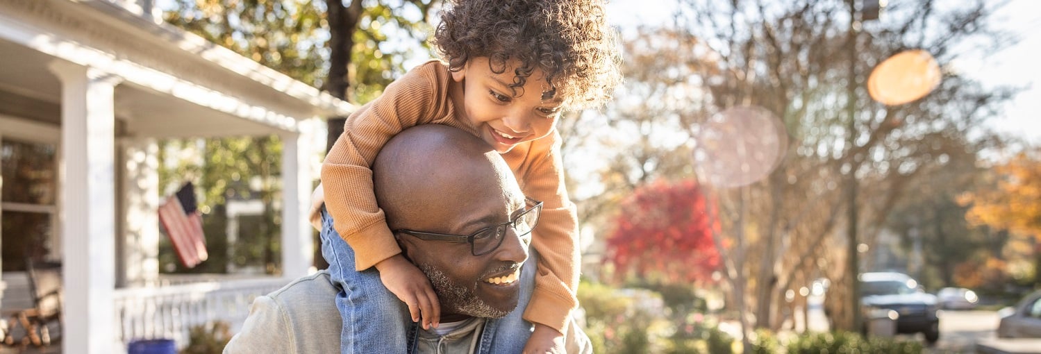 Man with child on his shoulders smiling