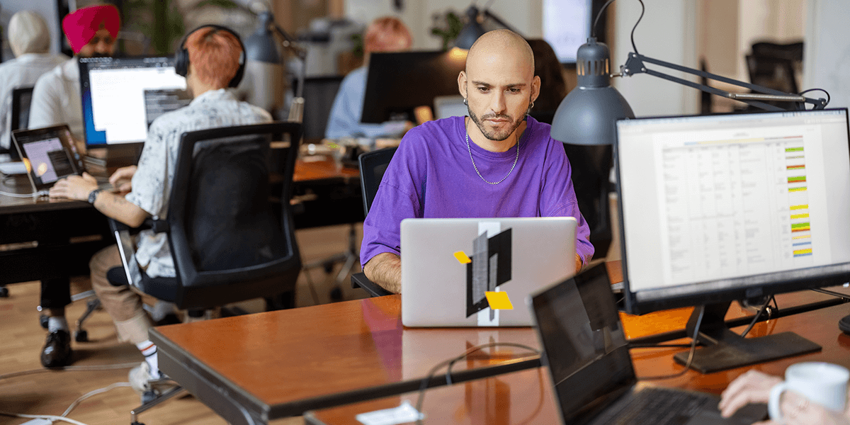 person-in-office-wearing-a-purple-shirt-and-using-a-laptop