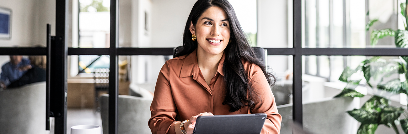 vrouw kijkt blij achter de laptop