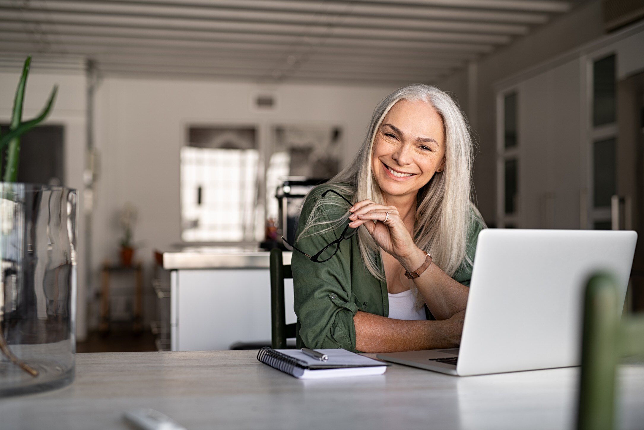 Woman sitting at table next to laptop