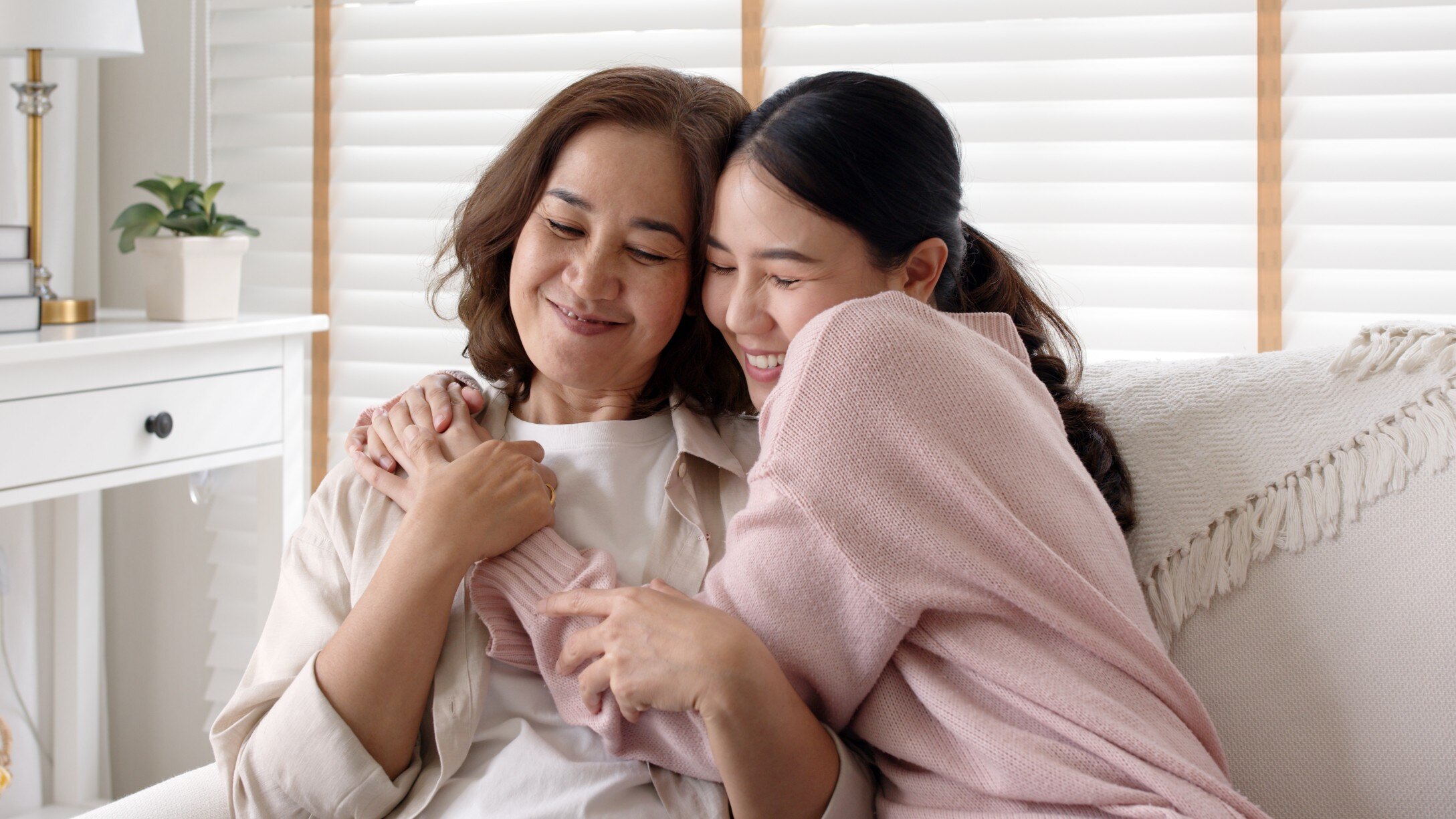 Daughter hugging mom on couch