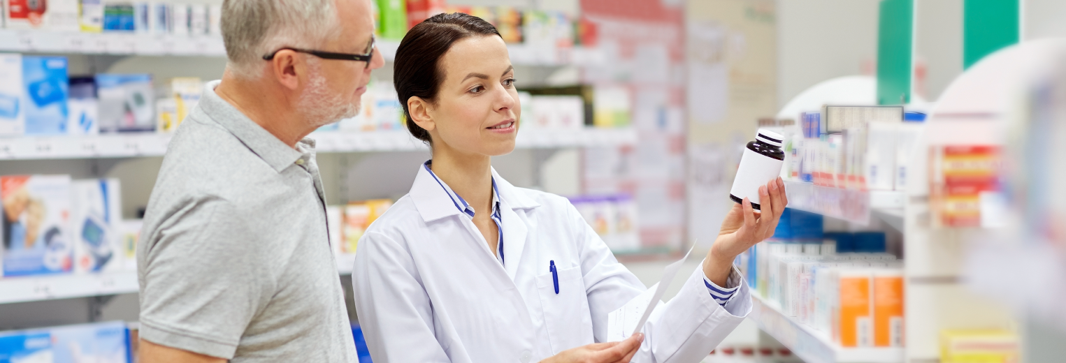 Pharmacist holding a pill bottle helping a patient