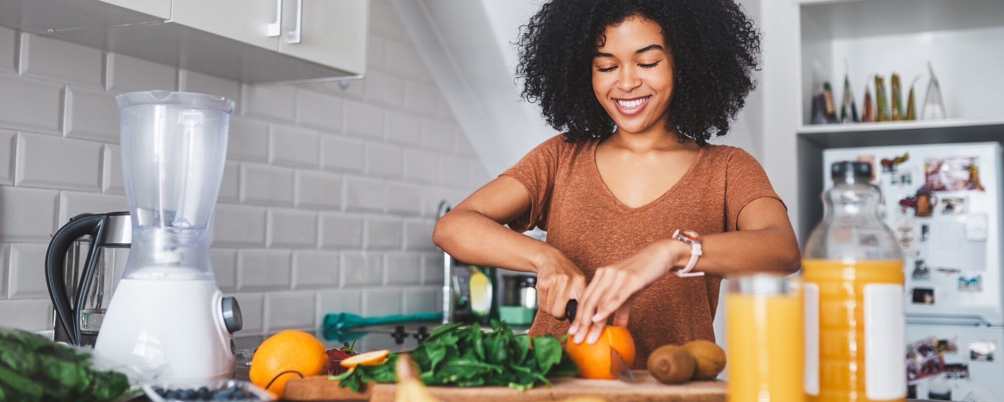 woman smiling and cooking with nutritious ingredients in her kitchen