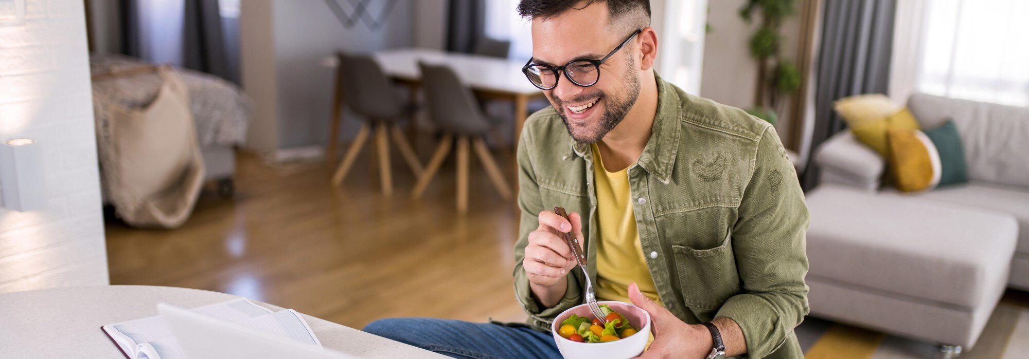 Homme qui mange une collation saine tout en travaillant de la maison