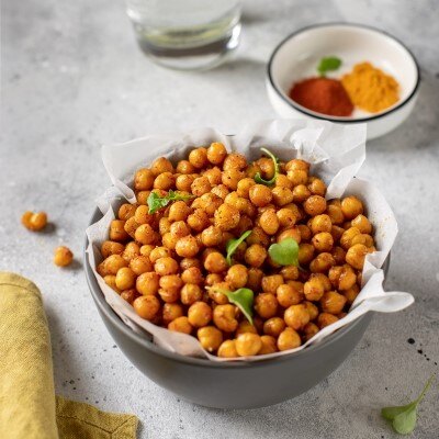 roasted chickpeas in a bowl next to some spices 