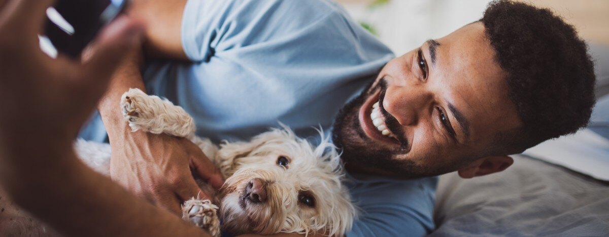 man with a healthy moustache spending time with his dog