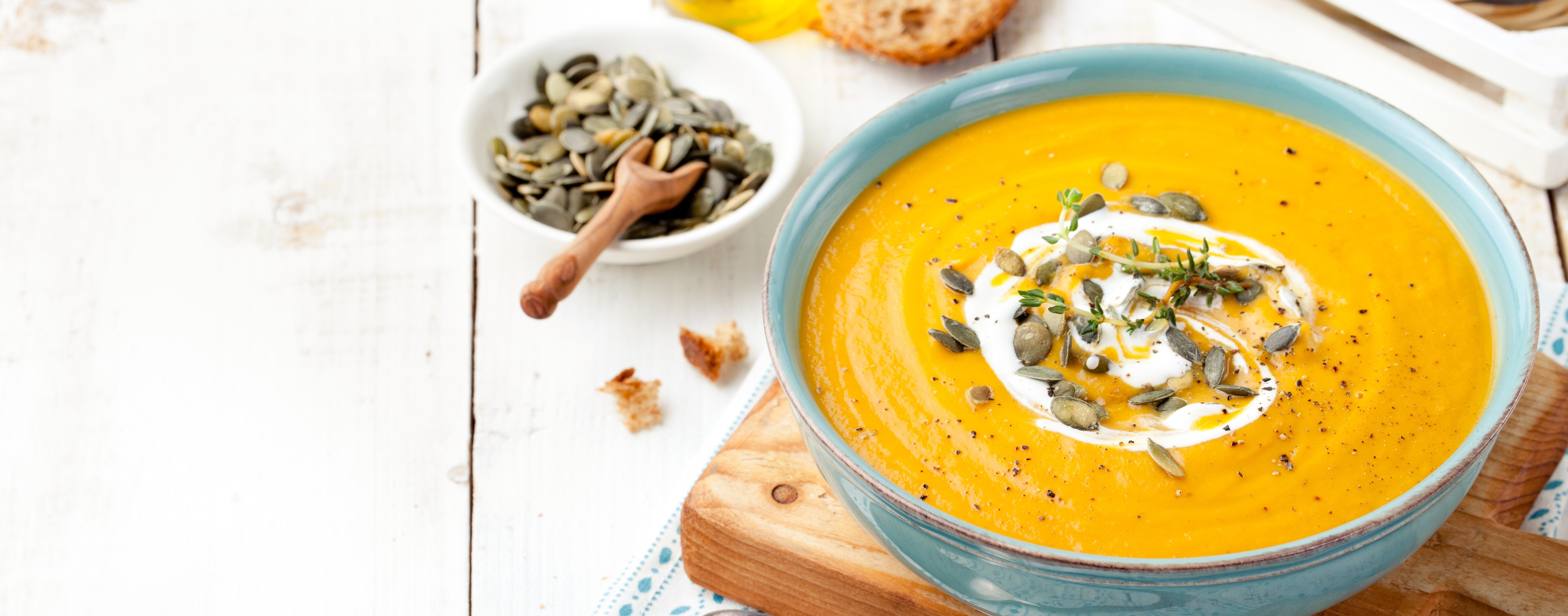 soupe aux pommes, aux poires et à la courge musquée au cari dans un bol bleu