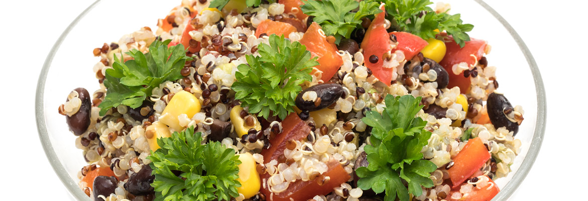 A grain bowl with quinoa, tomato, and black beans