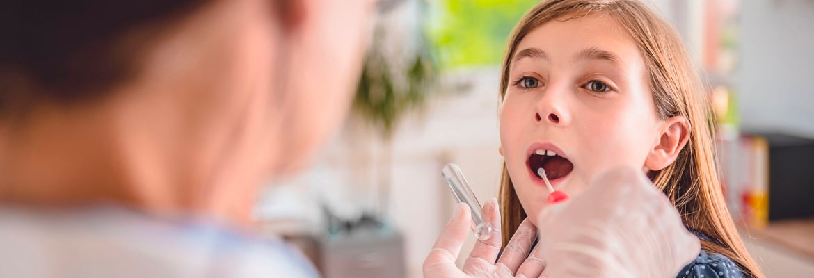 A doctor taking a mouth swab on a young girl