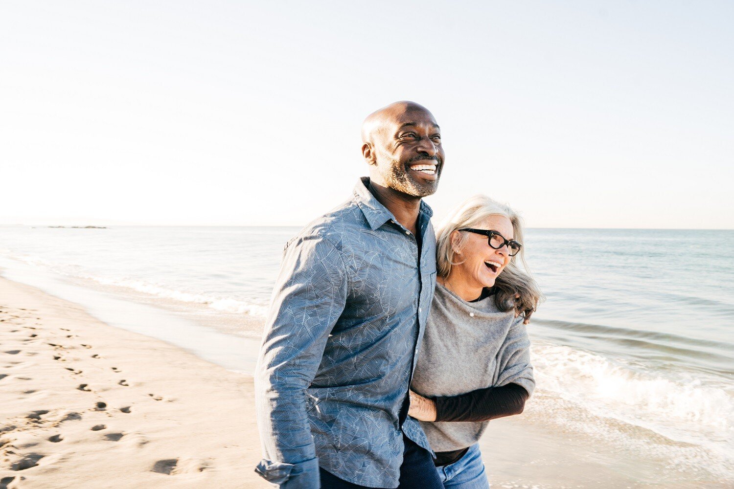 man and woman walking on the beach on a sunny day