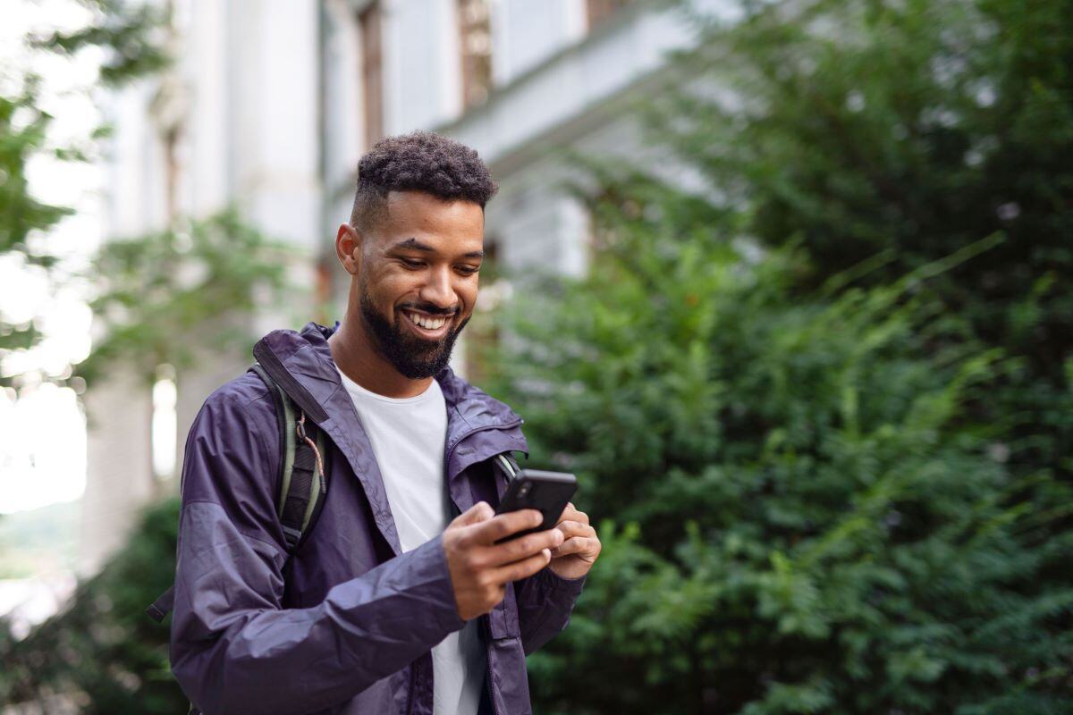 man walking with phone in hands.