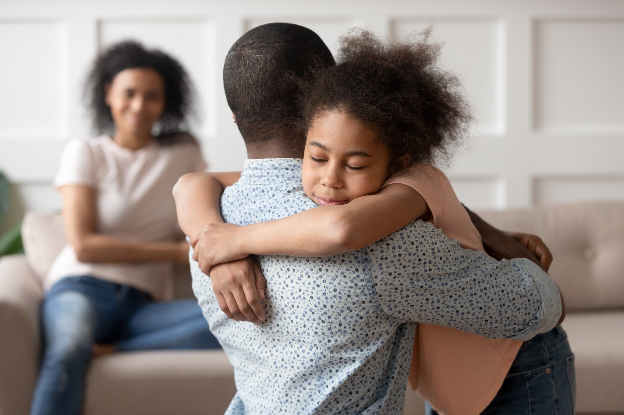 Daughter hugging dad at home