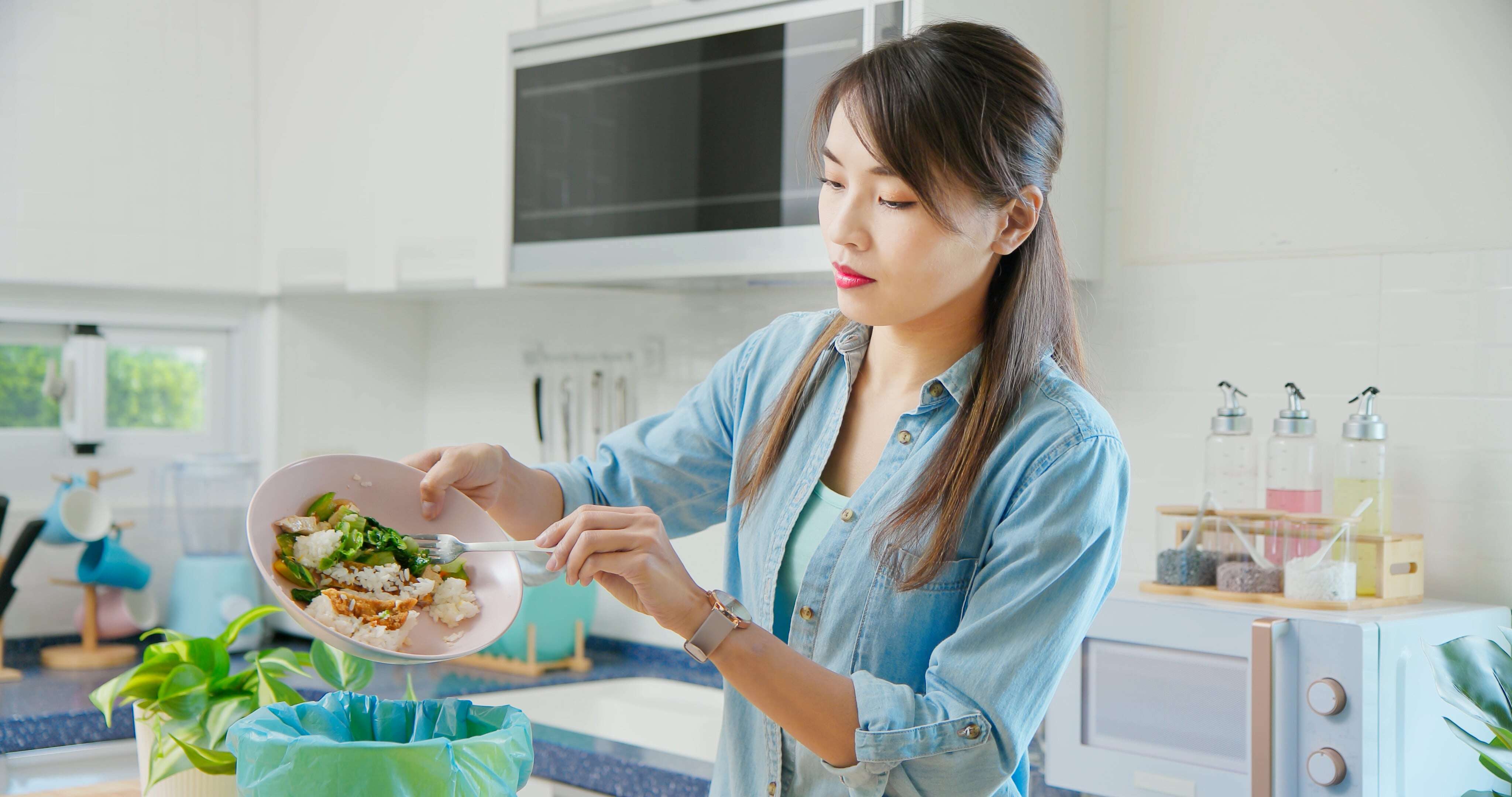 A woman putting food scraps away