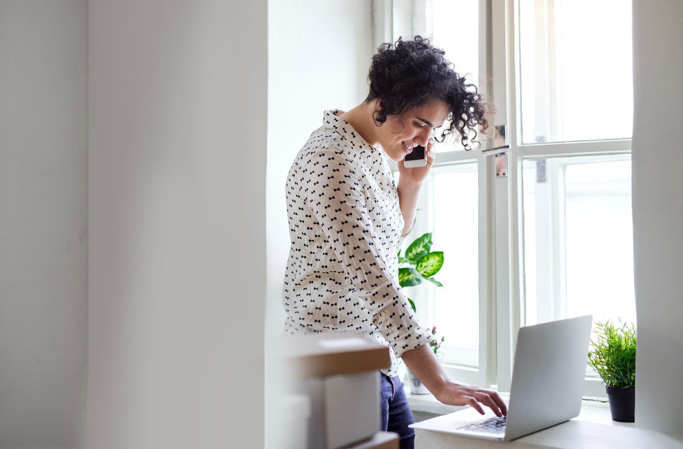 Woman standing at her desk on the phone