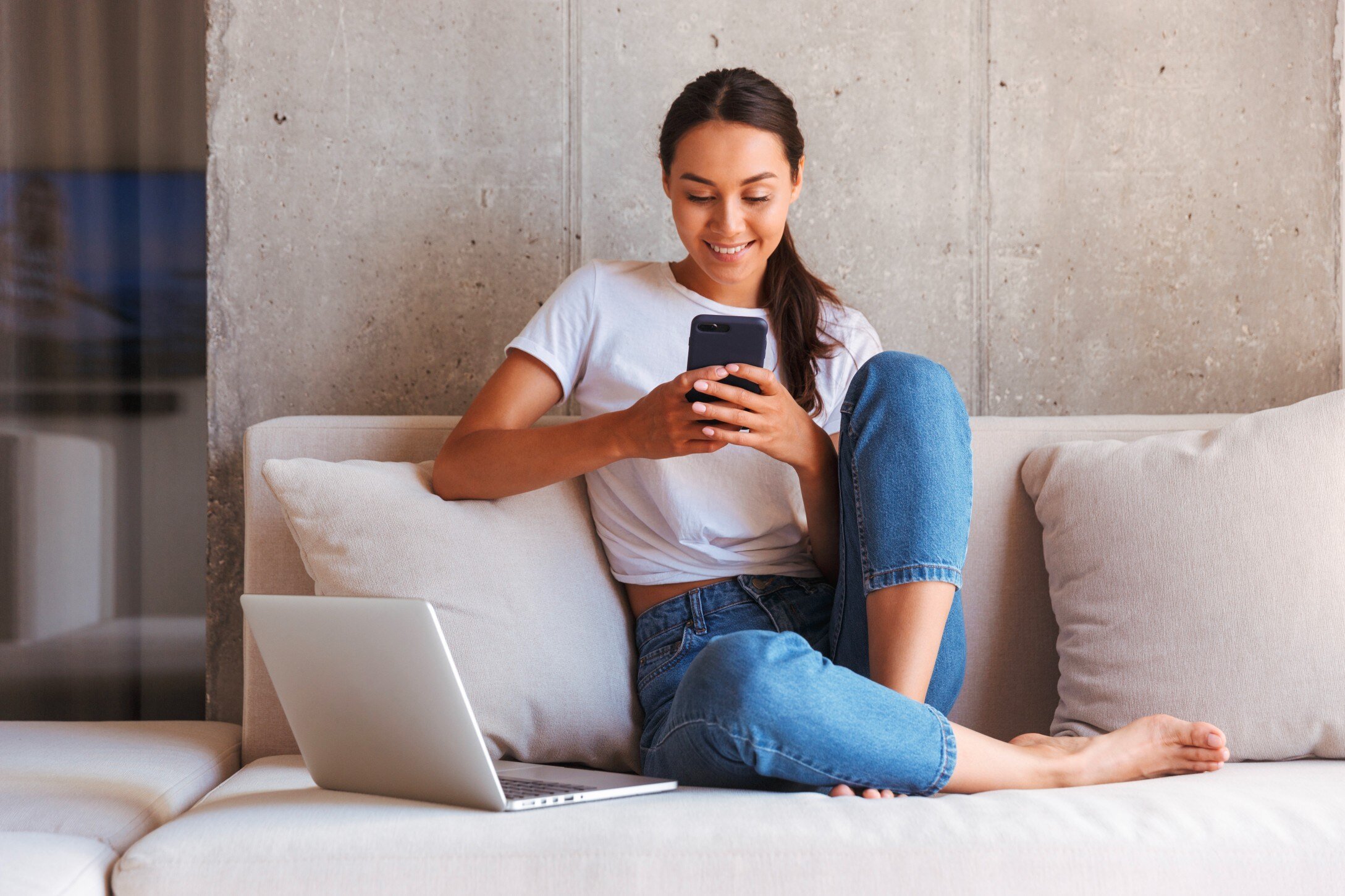 Woman sitting on couch with smart phone