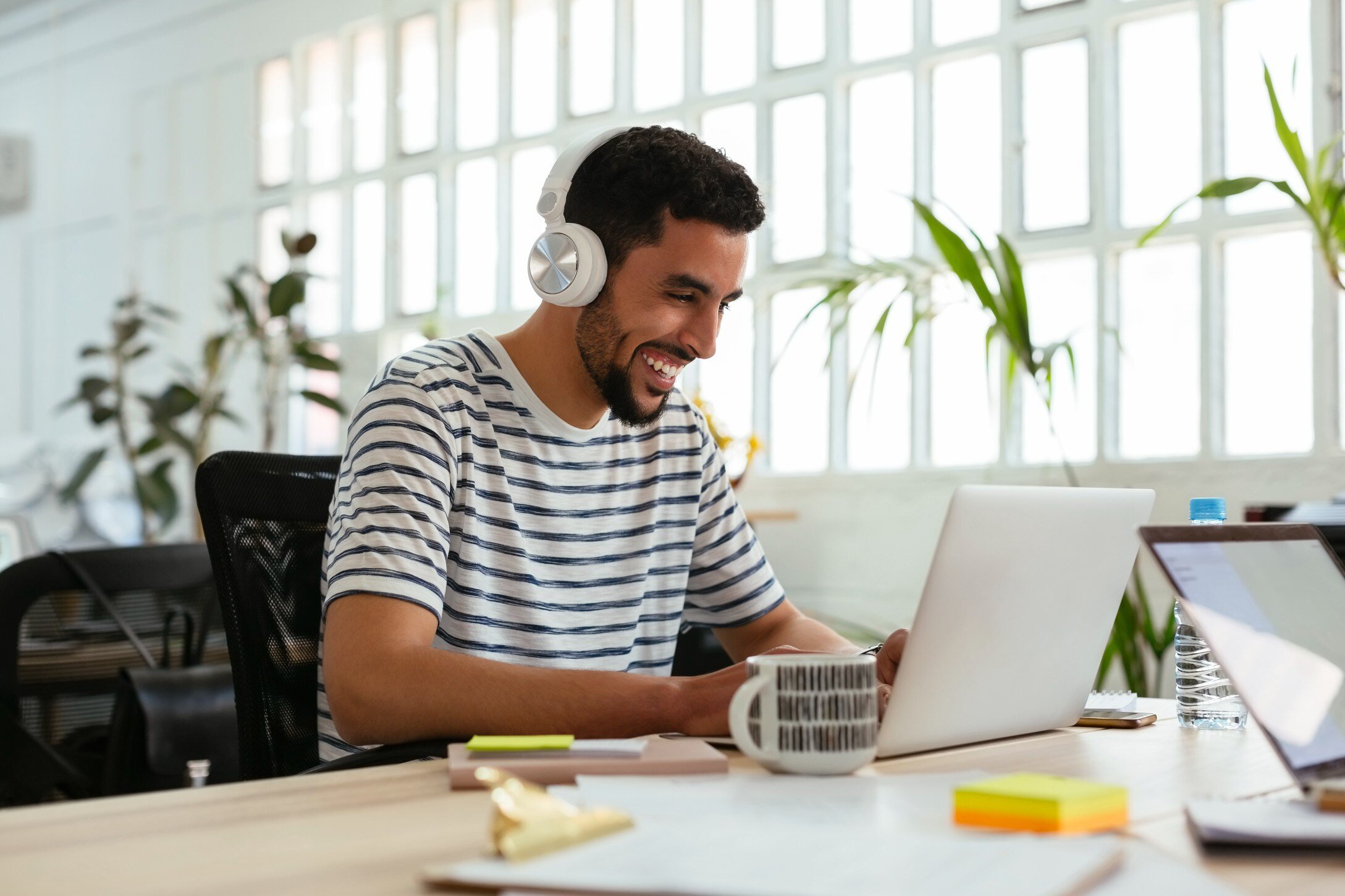 Man wearing headphones typing on laptop