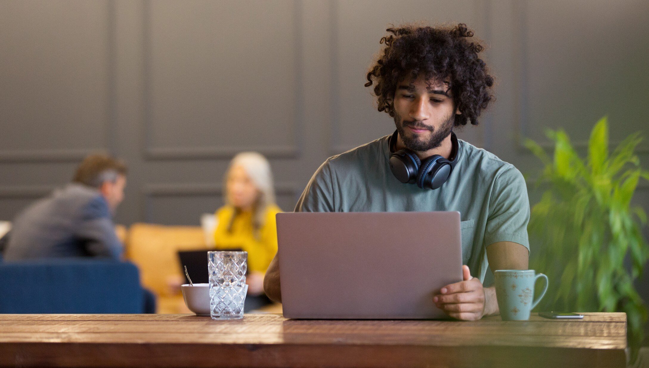 Man sitting at desk with laptop and headphones