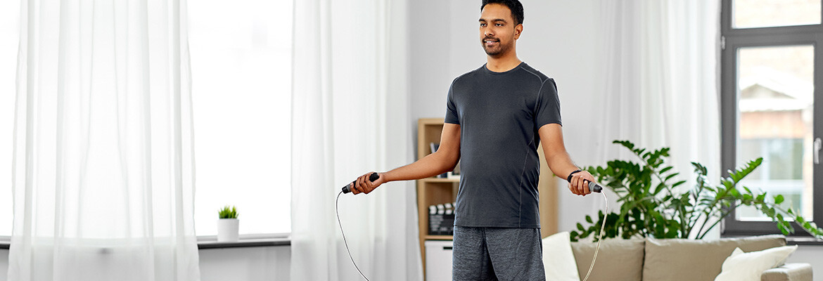 A man in workout clothes doing jump rope