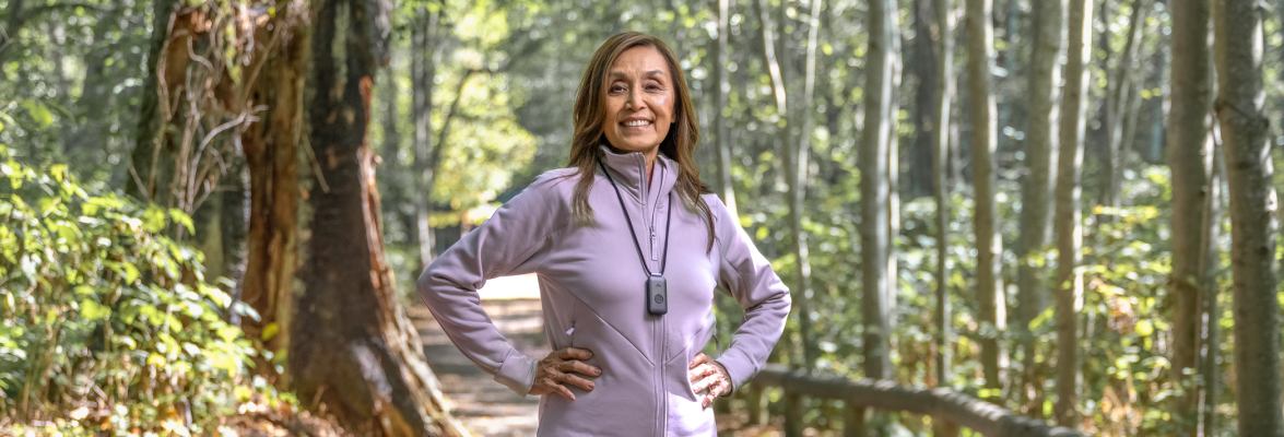 Femme dans la forêt avec un pendentif d’alerte médicale de TELUS Santé