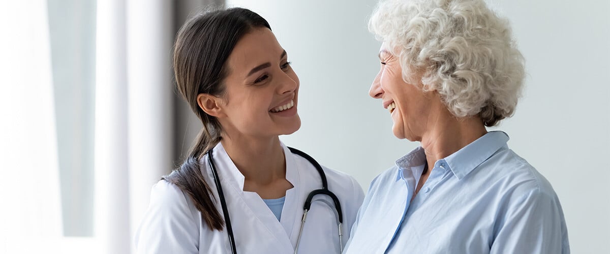 Female doctor smiling at senior female patient